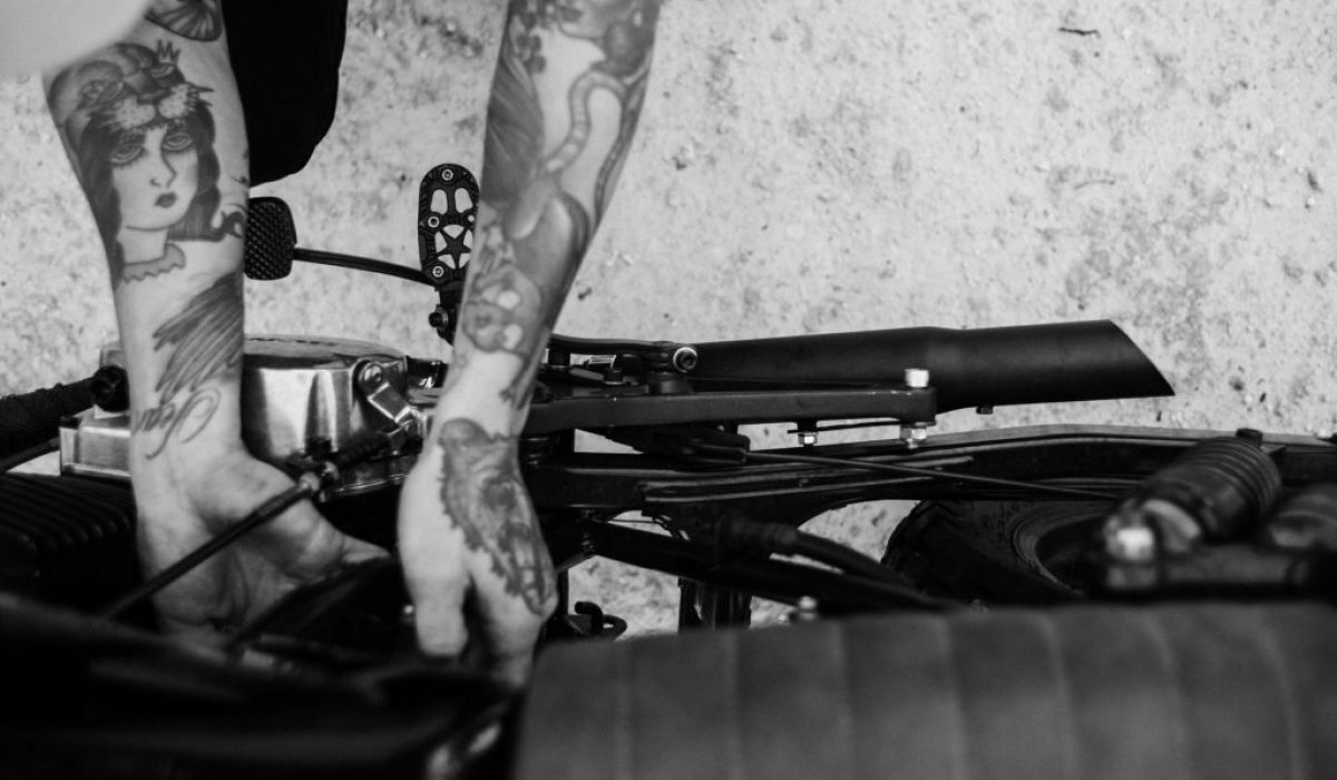 tattooed-biker-fixing-engine-of-motorcycle-4857741/