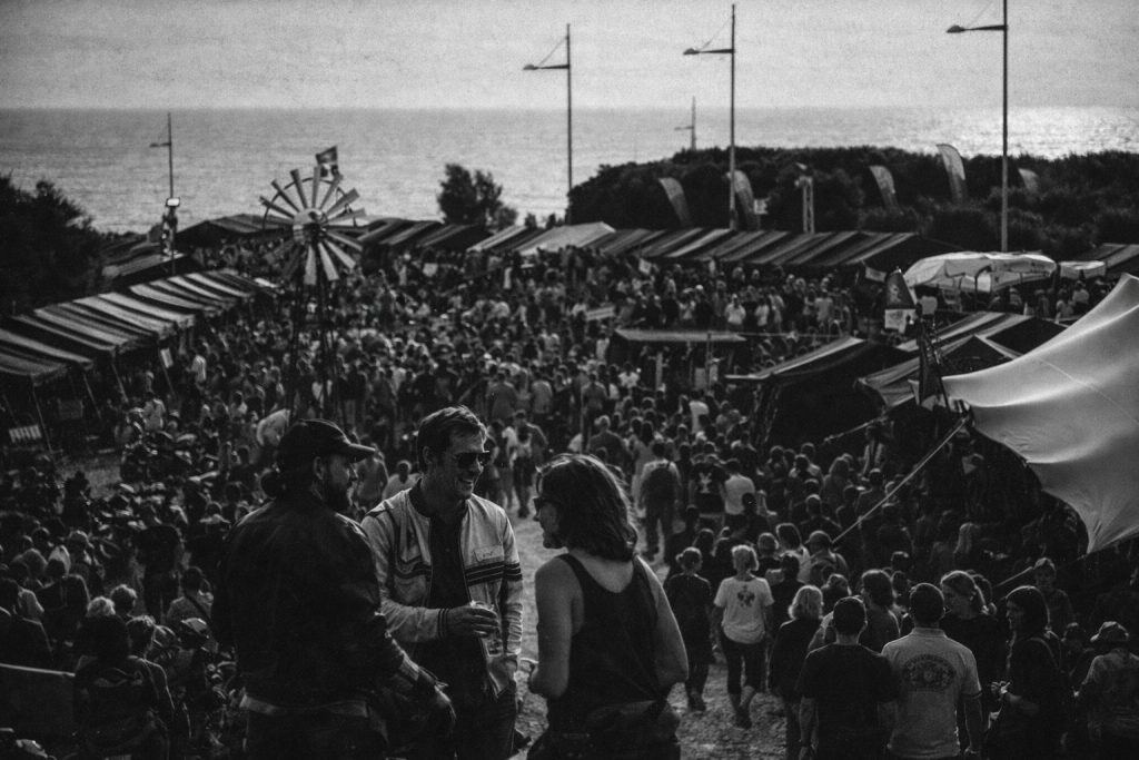By mid-afternoon, the crowd thickens around the tents and pathways, with riders and visitors moving steadily between the shoreline and the makeshift village.