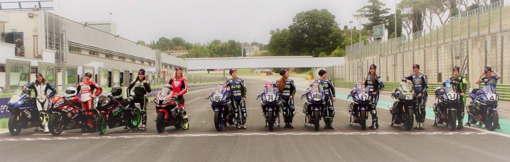 women-motorcycle-racers-standing-next-to-their-bikes-at-the-track-starting-line