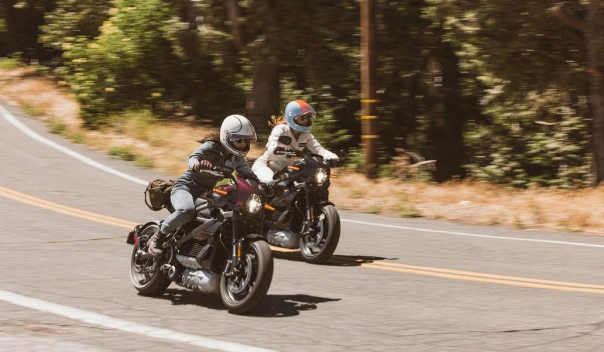 Two riders traveling side by side on LiveWire electric motorcycles on an open road.